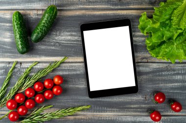 Çeri domatesleri, salatalık, salatalık, marul, biberiye ve siyah ahşap masanın üzerine tablet. Salata tarifi, vejetaryen menüsü