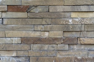 Modern tasarım gri taş duvar. Düz taş bloklar. Taş duvardaki dikişler. Siyah tahta duvar arkaplanı