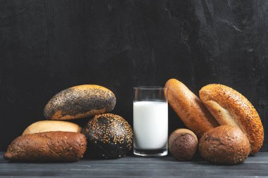 Siyah beton arka planda mini baget ve cam süt. Uzayı kopyala Yemek tarifi. Menü