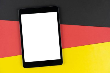 Kara tablet, e-kitap Almanya bayrağında. Doku Alman ulusal bayrağı renkli karton. Model yap, boşluğu kopyala, düzenle.