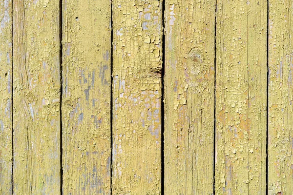 漆成黄色的木板正在从时间上剥落 油漆剥去了旧木板表面的皮 旧漆木木板的结构 — 图库照片