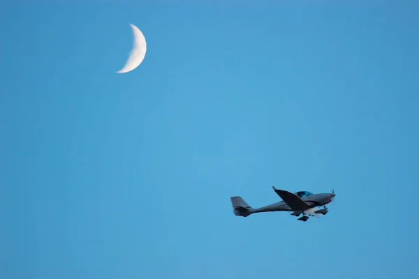 Avião voa acima da terra perto da lua — Fotografia de Stock