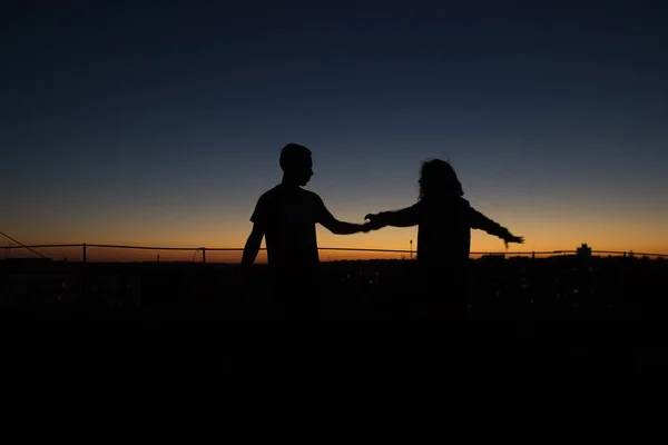 Silhouet paar scenario spelen bij zonsondergang — Stockfoto