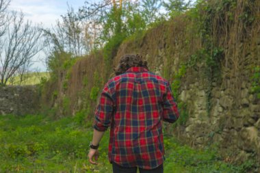 Ciddi yakışıklı delikanlı kale duvarının yakınında kareli gömlek