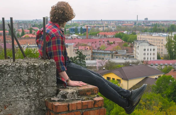 Ciddi yakışıklı delikanlı çatı kale duvarı, kareli gömlek