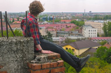 Ciddi yakışıklı delikanlı çatı kale duvarı, kareli gömlek