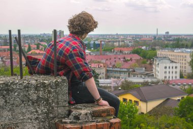 Ciddi yakışıklı delikanlı çatı kale duvarı, kareli gömlek