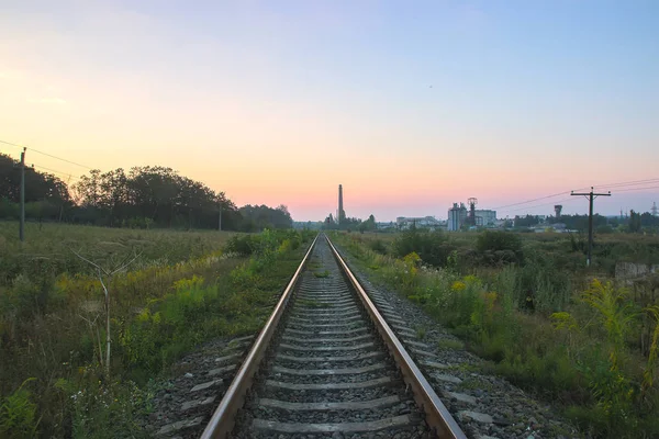 Ferrovia perto de linhas de alta tensão no céu dramático — Fotografia de Stock