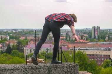 Ciddi yakışıklı delikanlı çatı kale duvarı, kareli gömlek