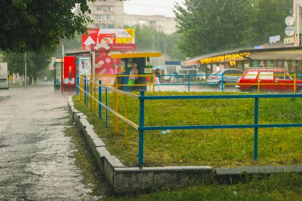 Regna bevattnar släppa faller till ytvattnet på gatan — Stockfoto