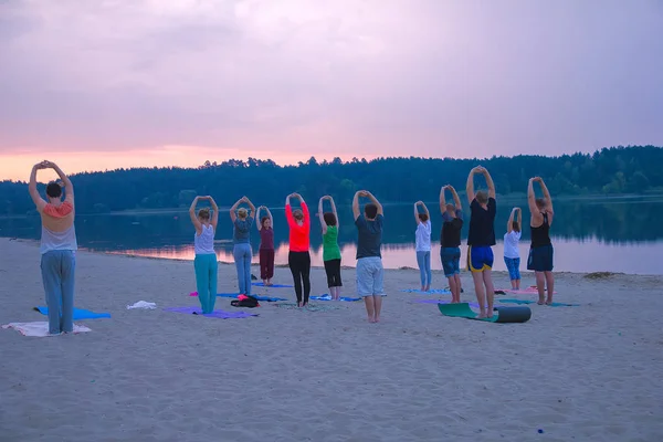 Zhytomyr, Ukraine - August 9, 2015: People practicing yoga at sunrise — Stock Photo, Image