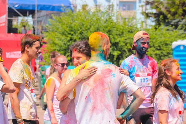 Zhytomyr, Ukrayna-25 Haziran 2016: Holi Fest 'te renkli toz bulutu çalıştırmak rekabet altında mutlu insanlar kalabalık parti