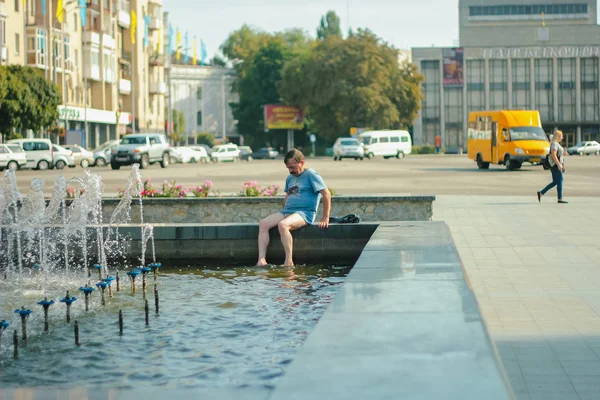 Житомир, Украина - 12 июля 2014 года: Старик бежит от жары в городском фонтане в центре — стоковое фото