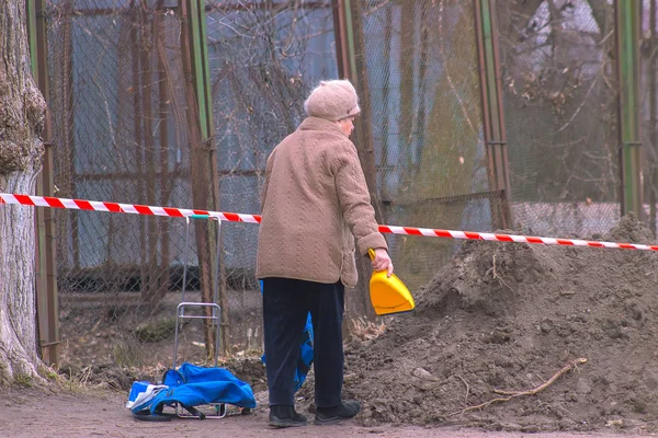 Житомир, Украина - 03 сентября 2015 г.: Старуха собирает песок — стоковое фото