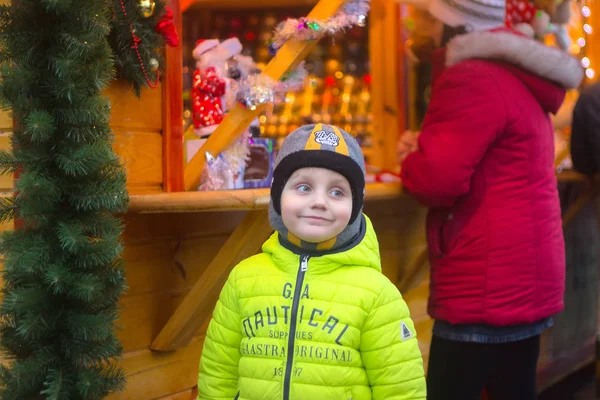 Zhytomyr, Ukraine - September 10, 2014: Very happy cute Boy with xmas gifts on wooden background. — Stock Photo, Image