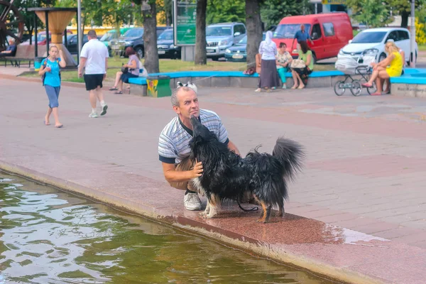 Zhytomyr, Ukrajna - szeptember 05, 2015-re: kutya nyal-a férfi-folyó közelében — Stock Fotó