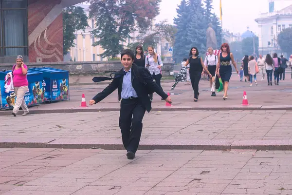 Житомир, Украина - 03 октября 2015 года: Счастливый школьник со школьной сумкой на плечах, бегающий по улице — стоковое фото
