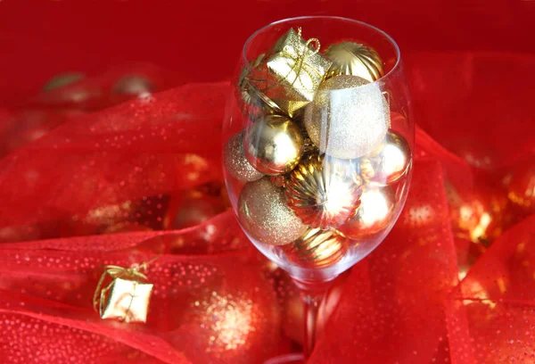 Fundo de Natal com vidro de videira e ouro decorações de Natal dentro dele. Copo de videira com decorações de Natal — Fotografia de Stock