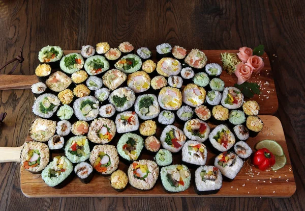 Sushi Set - Different Types of Maki Sushi and Nigiri Sushi. Served on dark wooden table.