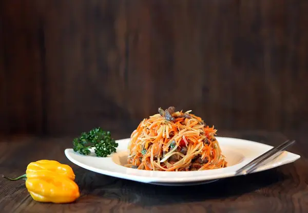 Пряный корейский морковный салат на тёмном фоне. Корё-сарам — стоковое фото