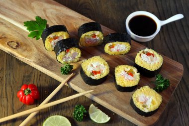 Suşi Seti - Maki Suşi ve Nigiri Suşi 'nin farklı türleri. Koyu ahşap masada servis edilir..