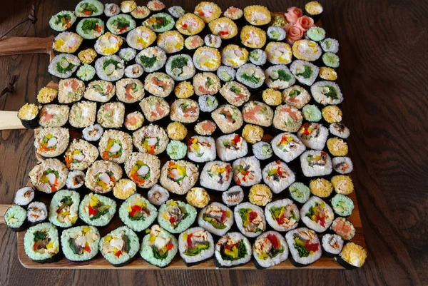 Sushi Set - Different Types of Maki Sushi and Nigiri Sushi. Served on dark wooden table.