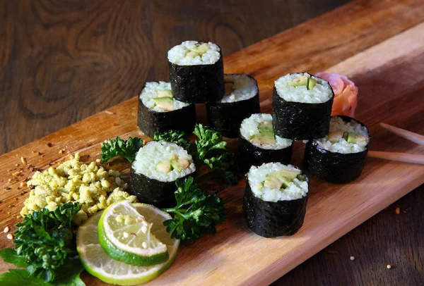 Sushi Set - Different Types of Maki Sushi and Nigiri Sushi. Served on dark wooden table.