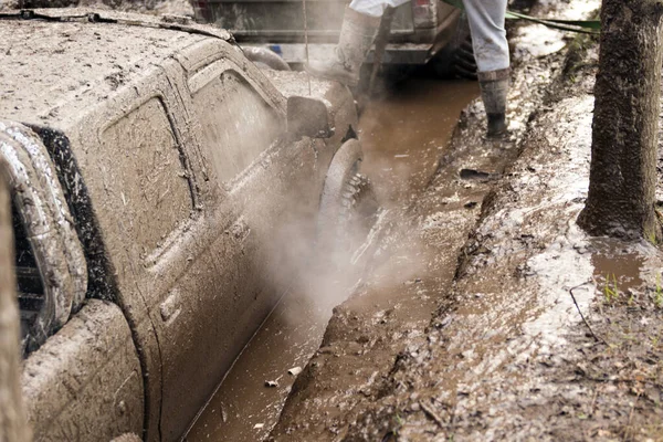 Off-road car going through deep mud holes. Detail of dirty car with filled mud - carwash concept. car wheels. dirty car wheel stands on forest road — Stock Photo, Image