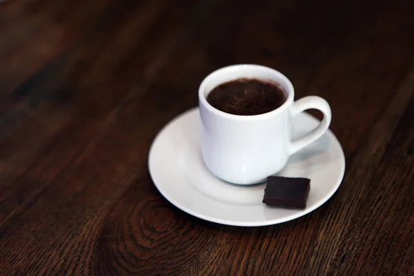 Secangkir kopi panas dengan latar belakang gelap. Cokelat panas dalam cangkir keramik putih. Cangkir teh dengan cokelat panas. Minuman lezat di cangkir porselen. Secangkir coklat panas meriah . — Stok Foto