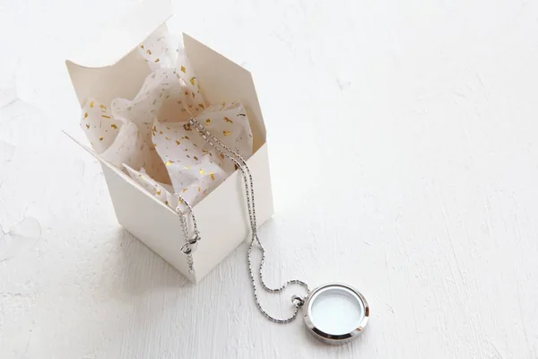 Srebrny naszyjnik na białym tle. Luksusowa srebrna biżuteria ze szkła w pobliżu pudełka na prezenty. Mały prezent dla niej. Piękne cenne kobiety biżuteria z miejsca kopiowania — Zdjęcie stockowe