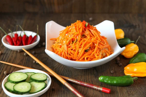 Морковь корейский мясной салат с палочками на деревянном дубовом столе — стоковое фото