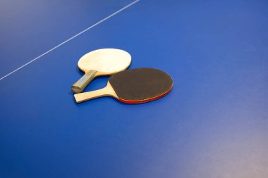 Tennis rackets for pingpong table tennis. details of pingpong table with playing equipment on a blue background. Ping-pong rackets on a table
