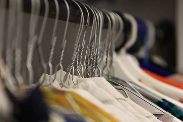 Kleding hanger close-up van fashion shop. aluminium hanger met kleding. kleren in een garderobe. Kleding van damesshirts op hangers in een kledingwinkel — Stockfoto
