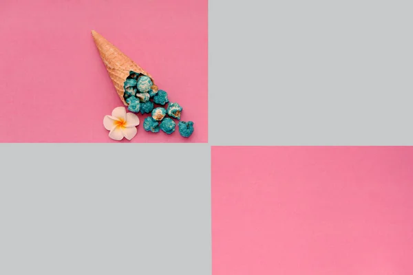 Popcorn spill out from waffle ice cream cone on pastel colorful background. Blue Popcorn on a cone cornucopia. Top view bright hipster background. Fast food. — Stock Photo, Image