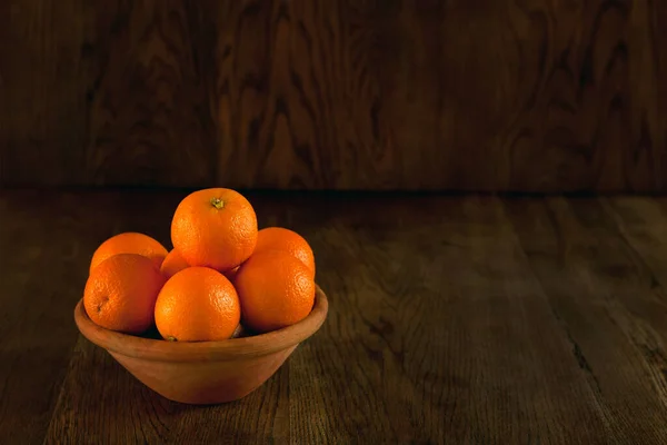 Muitas laranjas na tigela - fundo escuro. Ainda frutos de vida em estilo vintage. laranjas na tigela foto escura — Fotografia de Stock