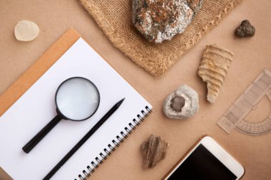Stone samples, loop, notebook and mobile phome at geological laboratory. Geology rock laboratory. Laboratory for analysis of geological soil materials, stones, minerals, rocks samples for researchers clipart