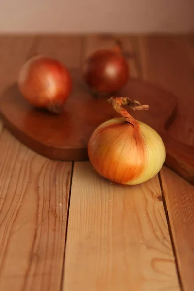 Cebolla y rodajas en tabla de cortar de madera. cebollas en la mesa de madera —  Fotos de Stock