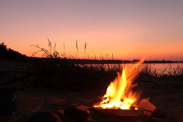 Beach Campfire on Lake. Red Superior sunset. red sunset evening. Fire onthe beach