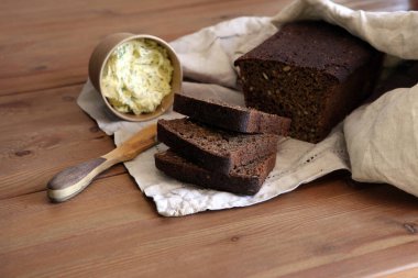 Taze ekmek dilimi ve kırsal masada bıçak kesme.