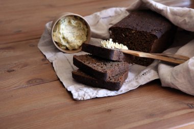 Taze ekmek dilimi ve kırsal masada bıçak kesme.