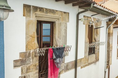 Deniz yansıma kuzeyinde giysilerle asmak ile bir pencerede 