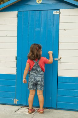 Arka görünümü meraklı kız dizili kapısını çalıyor