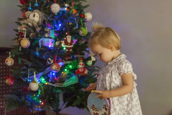 Fille à la maison mettant en place l'arbre de Noël avec des lumières et ornam — Photo