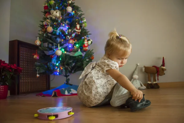 Fille à la maison mettant en place l'arbre de Noël avec des lumières et ornam — Photo