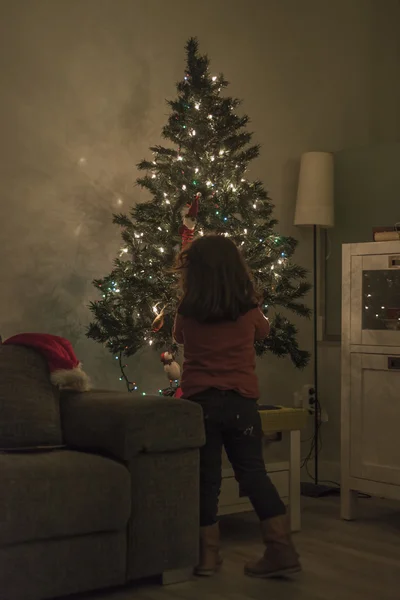 Dziewczyna, w domu ustawienie up christmas tree z oświetleniem i ornam — Zdjęcie stockowe