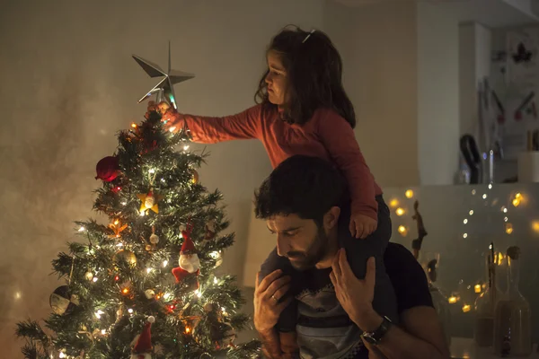 Kız ve baba yıldız, ışıklar ile Noel ağacı kurma ve