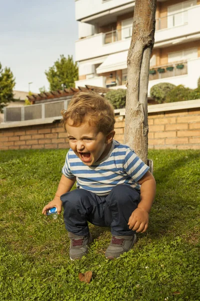 草の中の完全なショット肖像画かわいいスマイリー赤ちゃん男の子スクワット — ストック写真