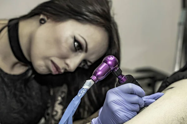 关闭了女人手用乳胶手套，在纹身店纹身 — 图库照片