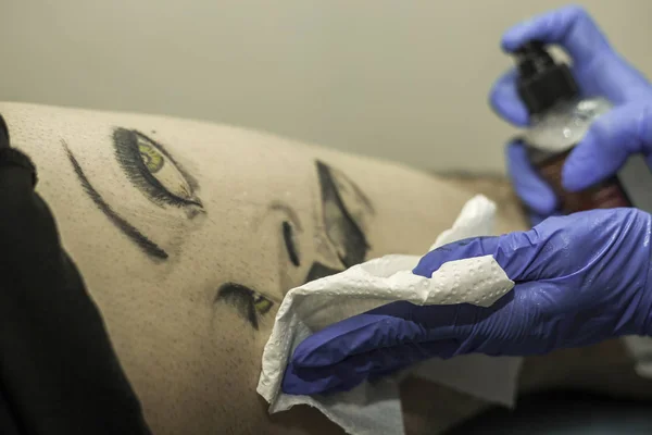Bir adam le dövme Temizleme profesyonel kadın tattooer kadar kapatın