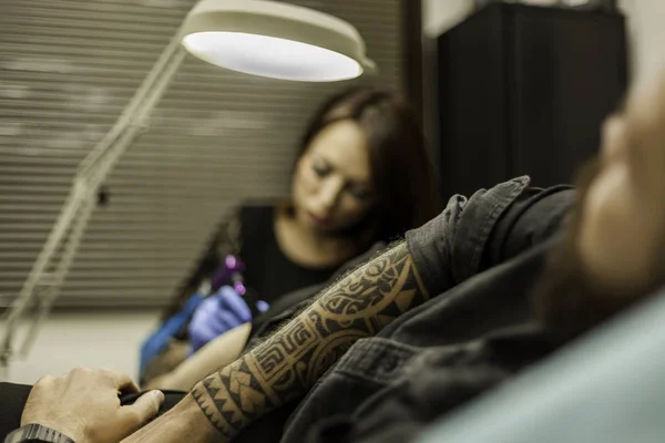 Close-up van tribal tattoo arm voor een client in tattoo studio — Stockfoto